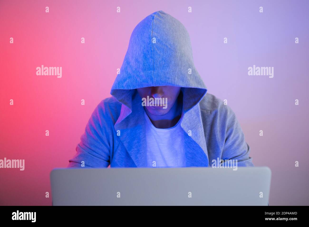 Gamer plays on a laptop. The programmer writes the code. Man on a colored background Stock Photo