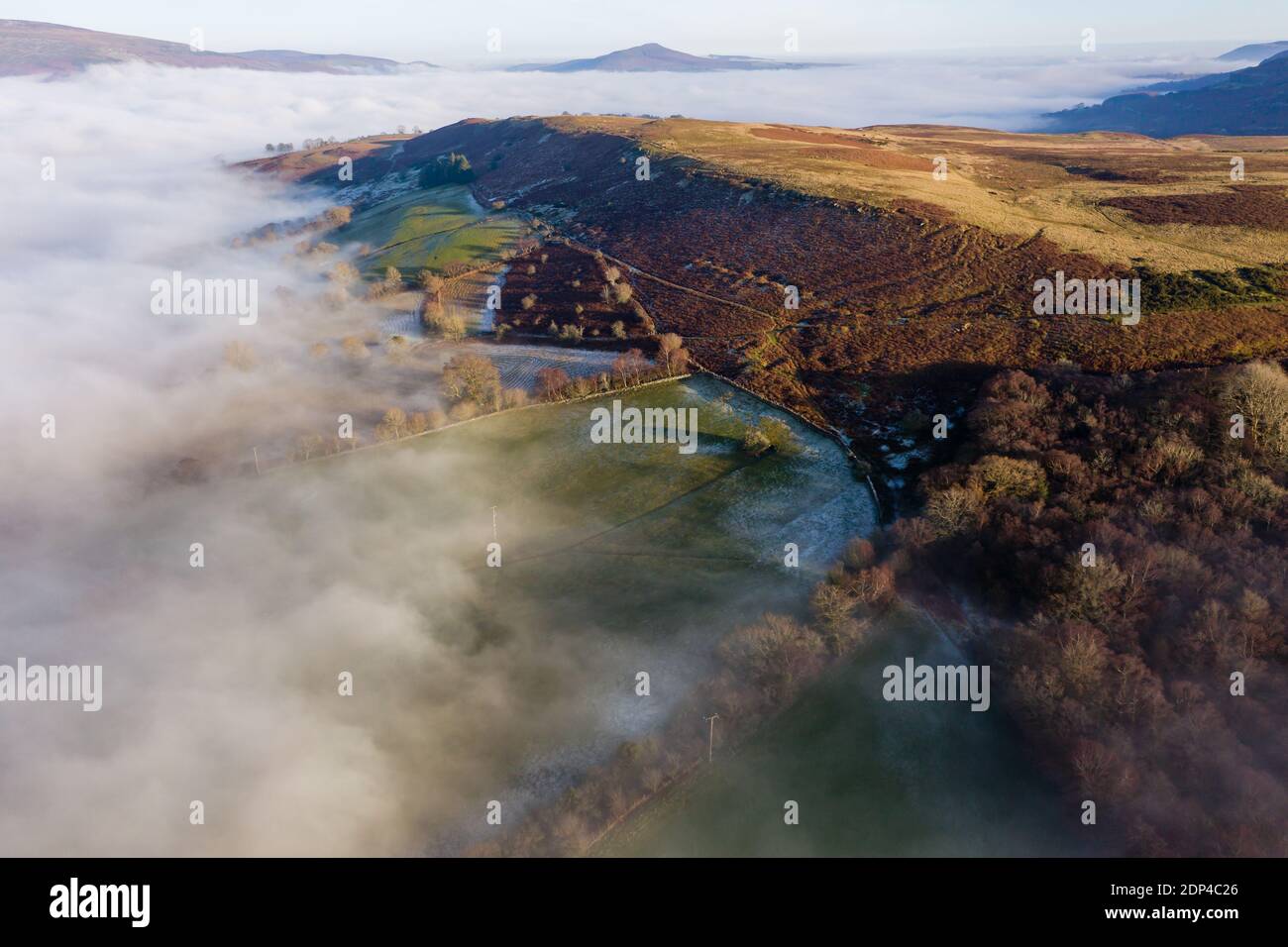 Aerial view looking down through fog on a frosty, frozen rural landscape (Wales, UK) Stock Photo