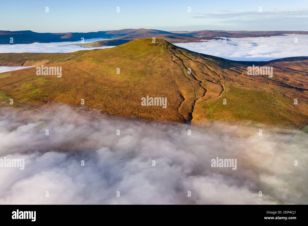 Aerial view of a mountain peak rising above a sea of low cloud and fog in the valley below (Sugar Loaf, Brecon Beacons, Wales) Stock Photo