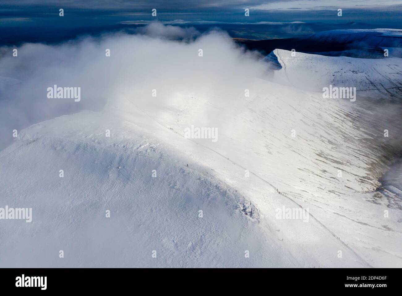 Aerial view of clouds moving over the summit of snow capped mountains ...