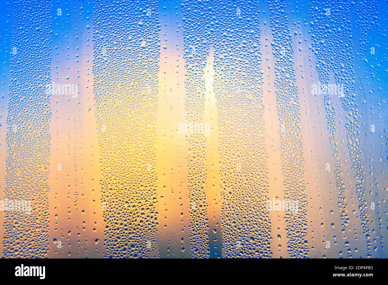 Water drops on the glass surface . Colorful wet surface with raindrops , Sunlight in the window Stock Photo