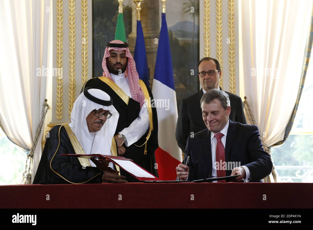 Jacques Repussart, director general of the French Institute for Protection from Radioactivity and Nuclear Safety IRSN (front, R) and Dr. Hashim Abdullah Yamani, the President of King Abdullah City for Atomic & Renewable Energy K.A.CARE (front, L) sign a memorandum of understanding for cooperation in radioactive waste management, as French President Francois Hollande and Saudi Deputy Crown Prince Muhammad Bin Salman, deputy premier, minister of defense and chairman of the Economic and Development Affairs Council look on during the signing of ten agreements at the Elysee Palace in Paris, France Stock Photo