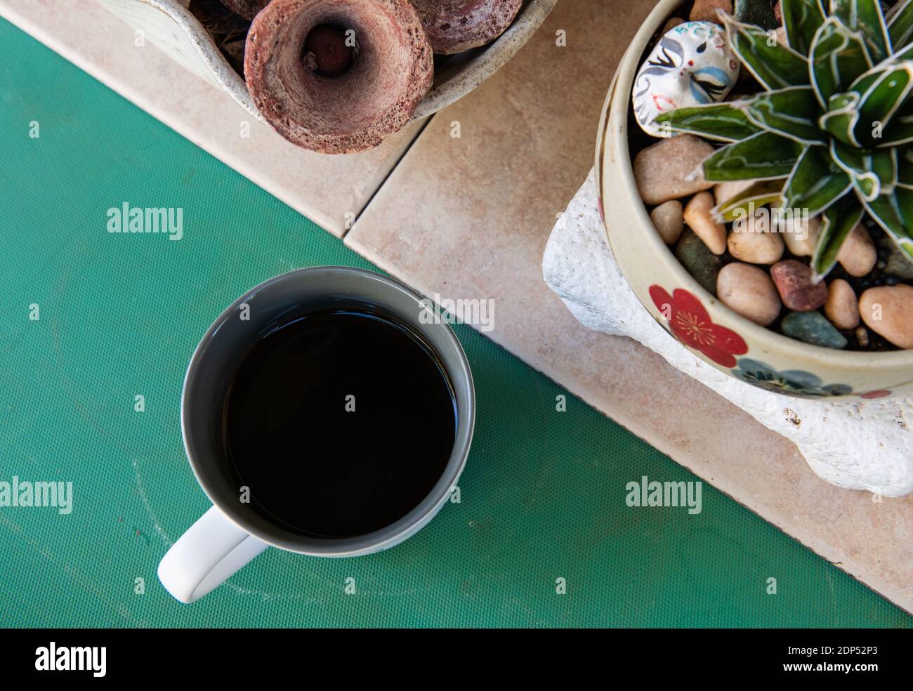 Fresh Brewed Coffee on Outdoor Table with Tiled and Green Surface Stock Photo