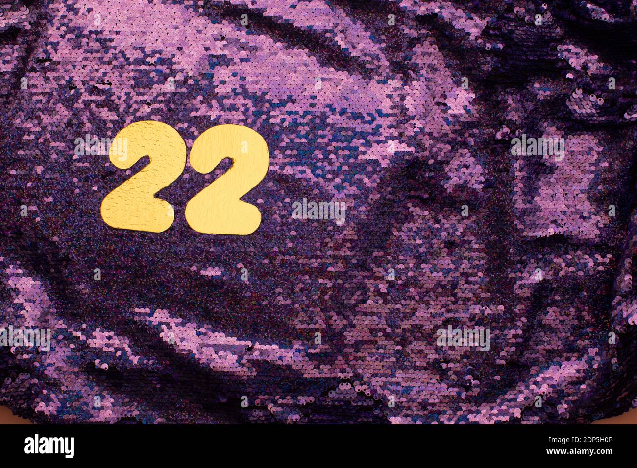 Gold numbers 22 on sequins glitter purple background Stock Photo