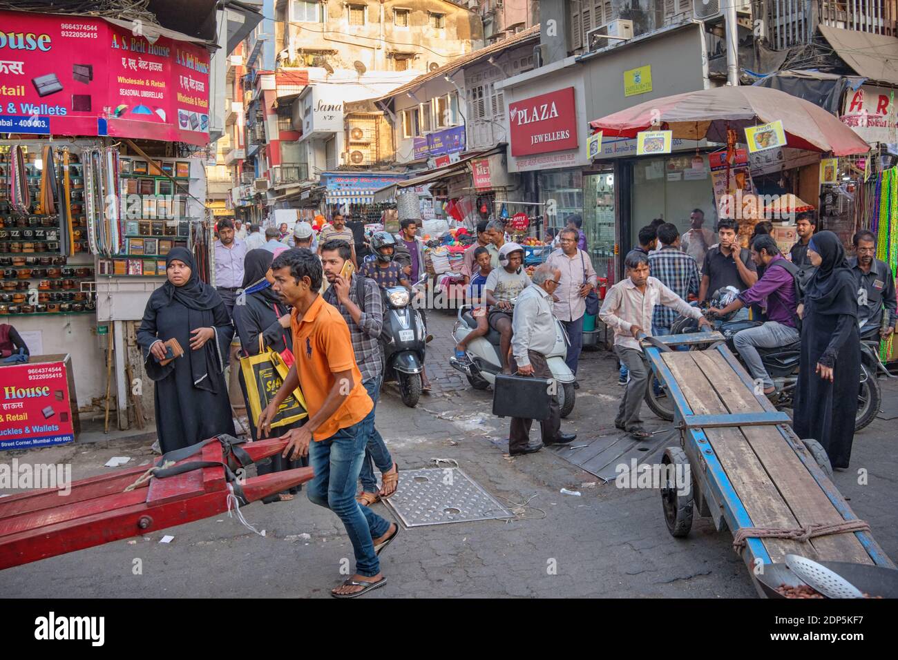Porters push their pushcarts through the busy and crowded lanes of
