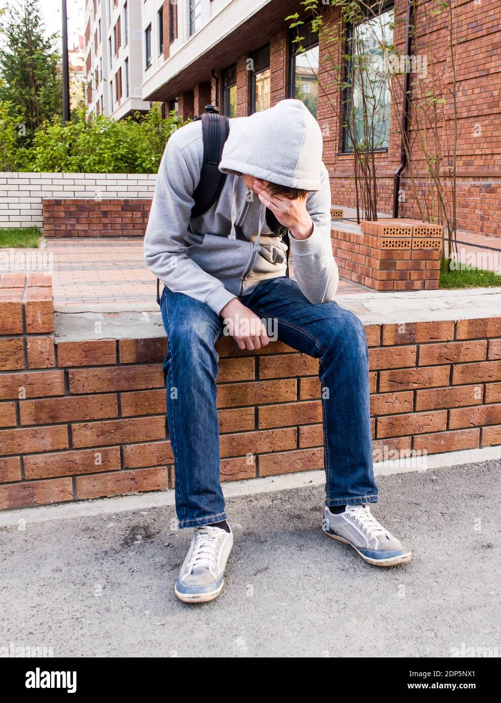 Sad Young Man sit on the City Street Stock Photo