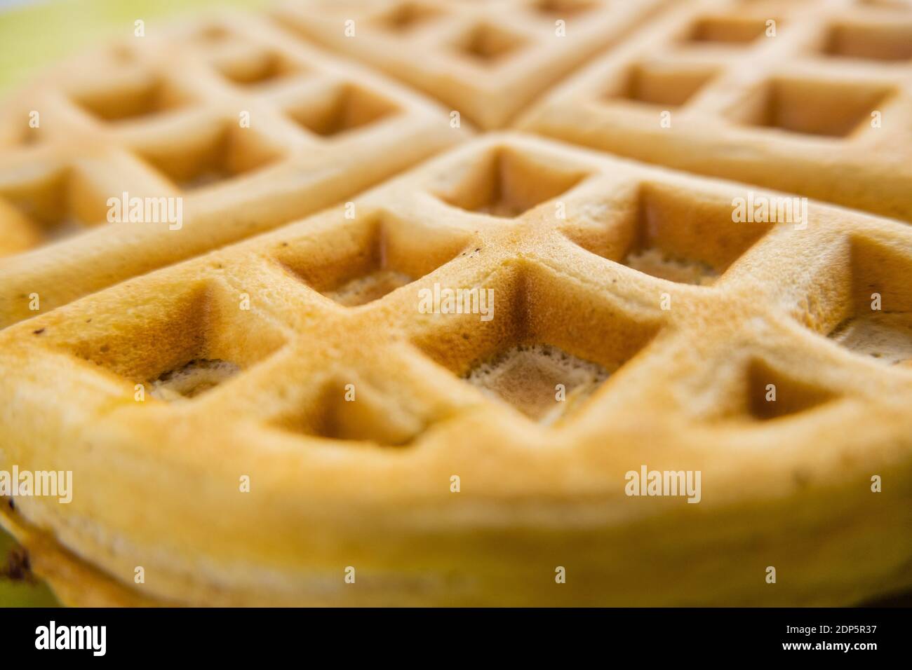 Fresh round waffle on a yellow plate upclose Stock Photo Alamy