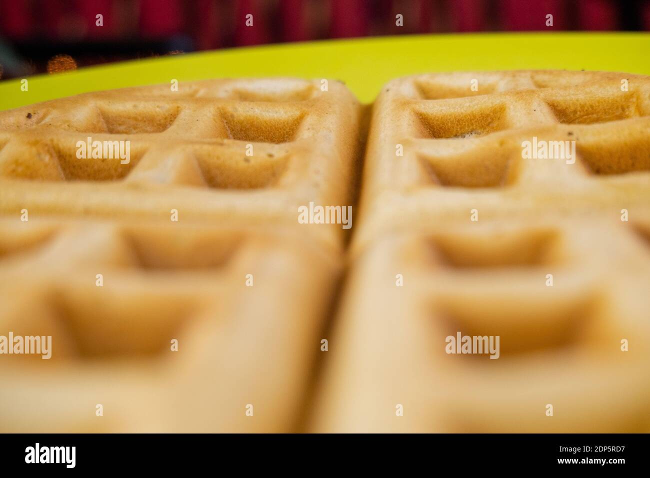 Fresh round waffle on a yellow plate upclose Stock Photo Alamy