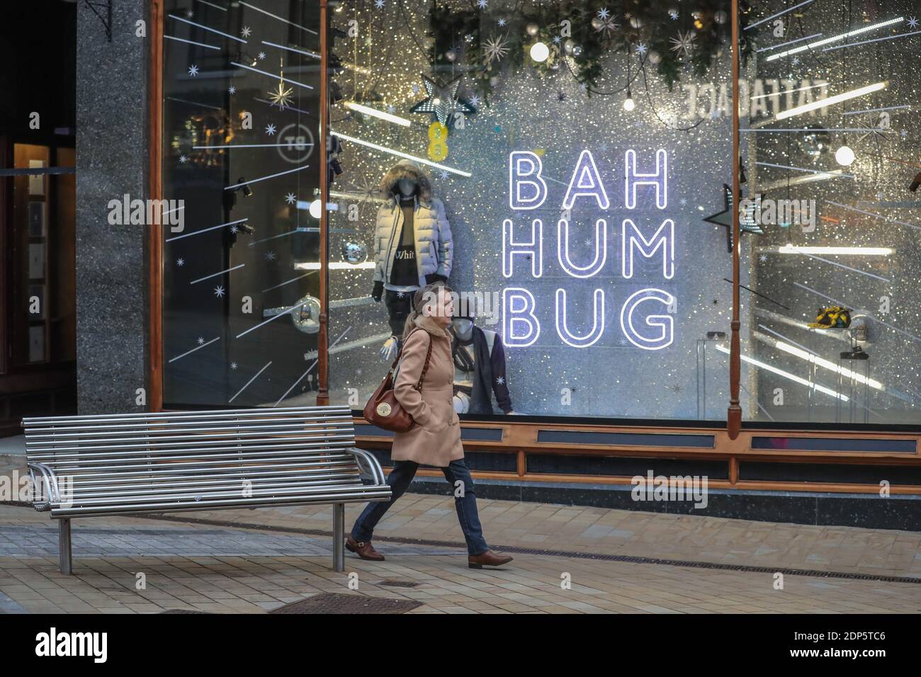 A early morning shopper walks past a sign saying ‘Bah Humbug’ In Leeds City Centre as the country’s second national lockdown restrictions end and drop to tier 3 in West Yorkshire Stock Photo