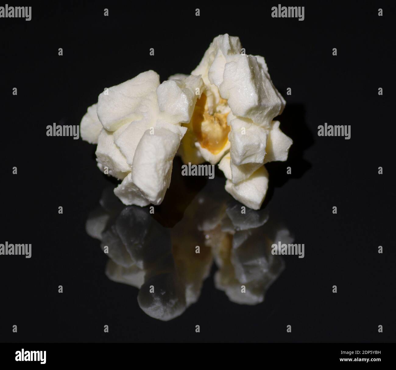 Popped popcorn isolated on black background. Reflection. Close up. Macro. Stock Photo
