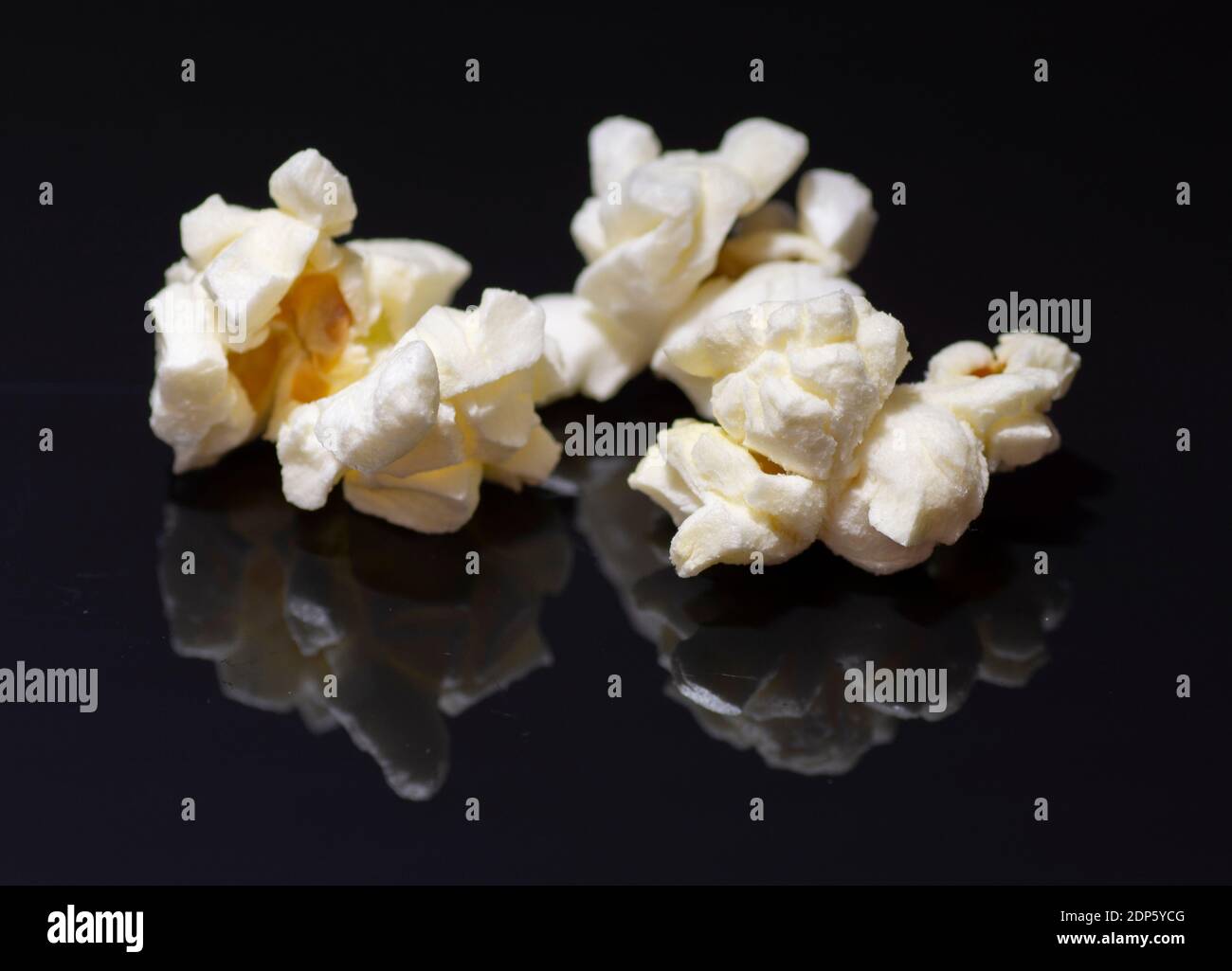 Popped popcorn isolated on black background. Reflection. Close up. Macro. Stock Photo