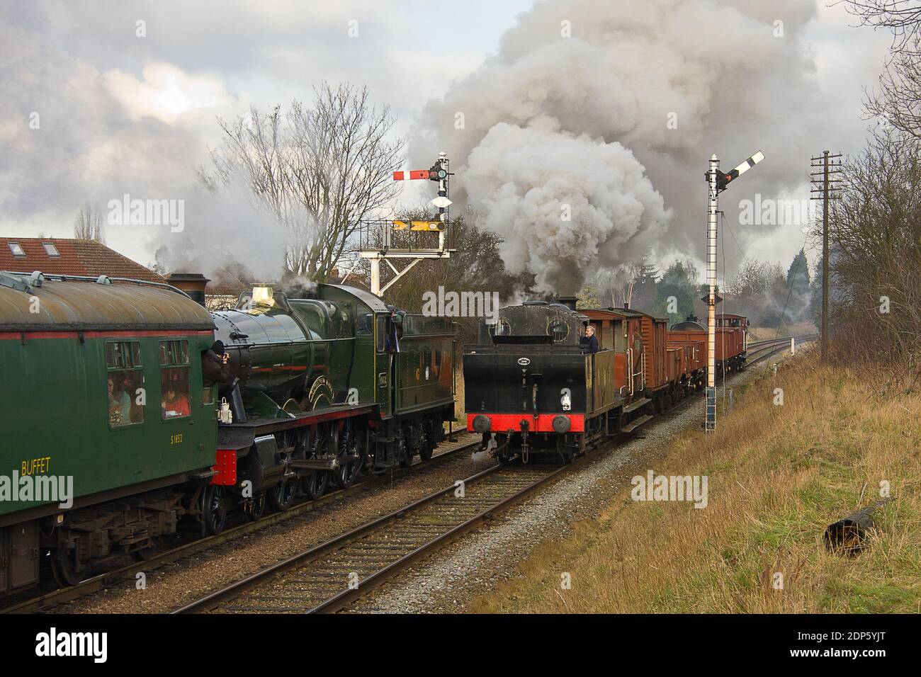 A checked GWR Hall Class 4-6-0 No. 4953 ‘Pitchford Hall’ is passed by Jinty 0-6-0T Class 3F No. 47406 outside Loughborough. Stock Photo