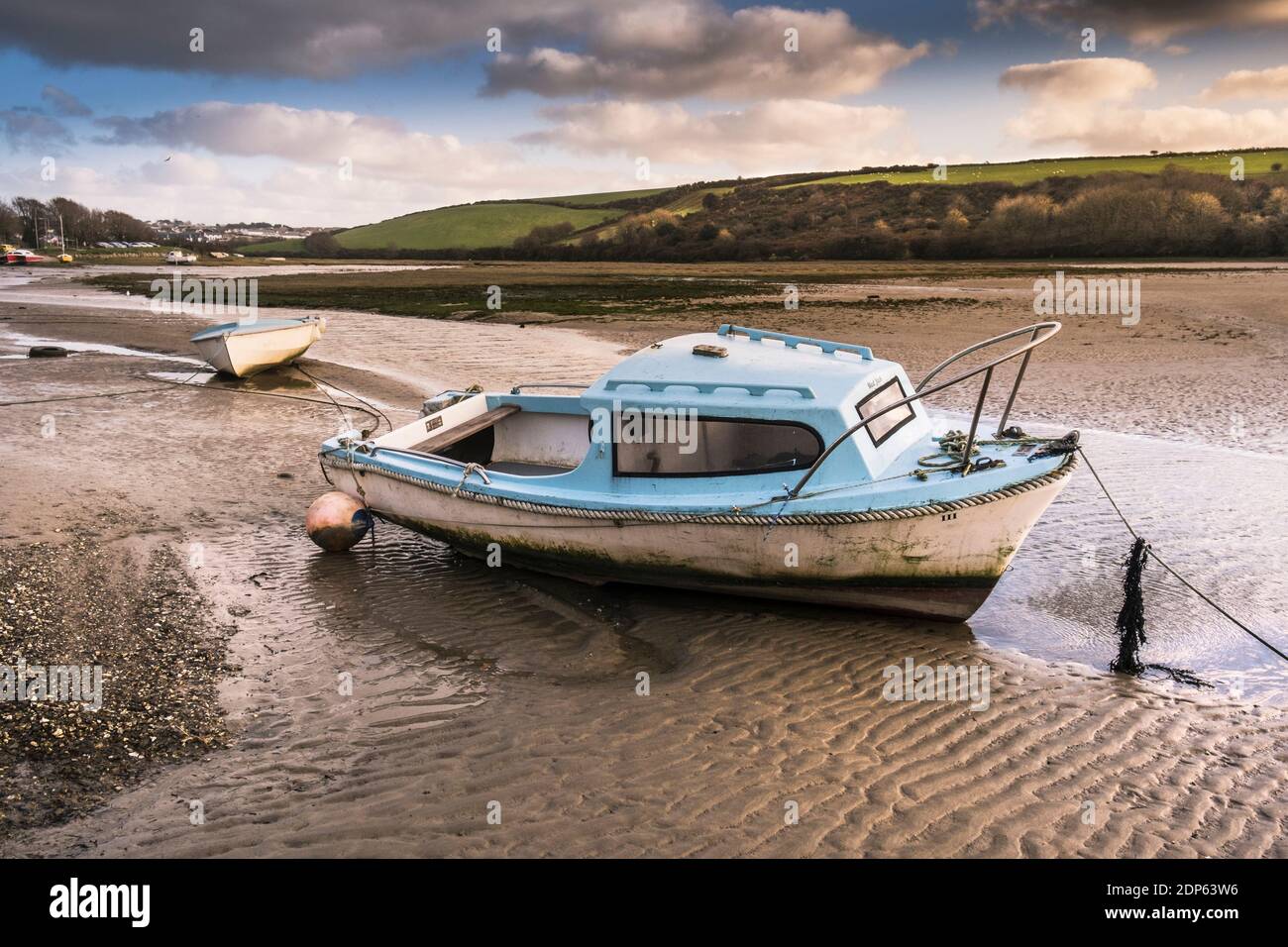 A motor boat moored at low tide on the Gannel River foreshore in
