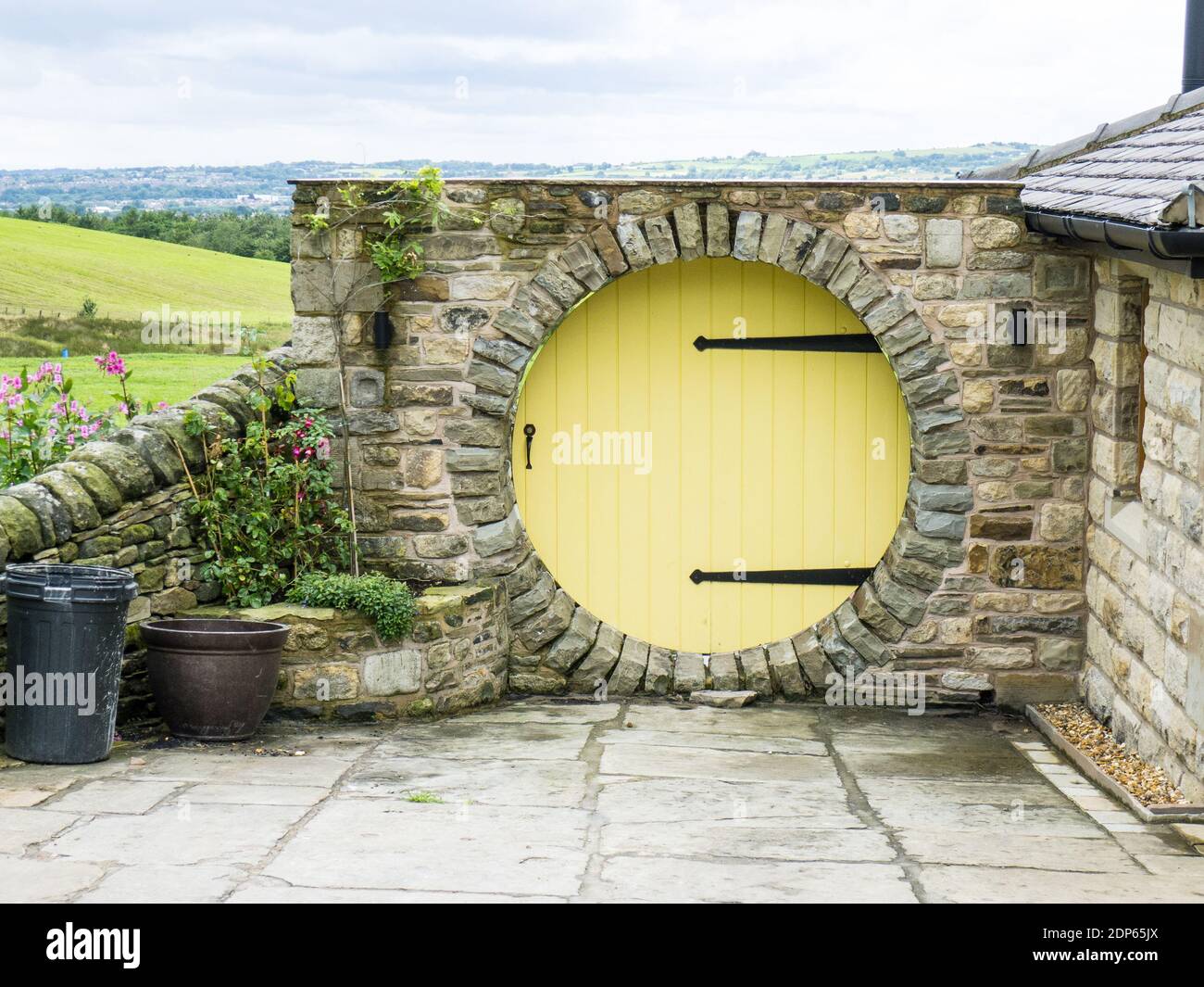 Circular yellow door in stone wall Stock Photo