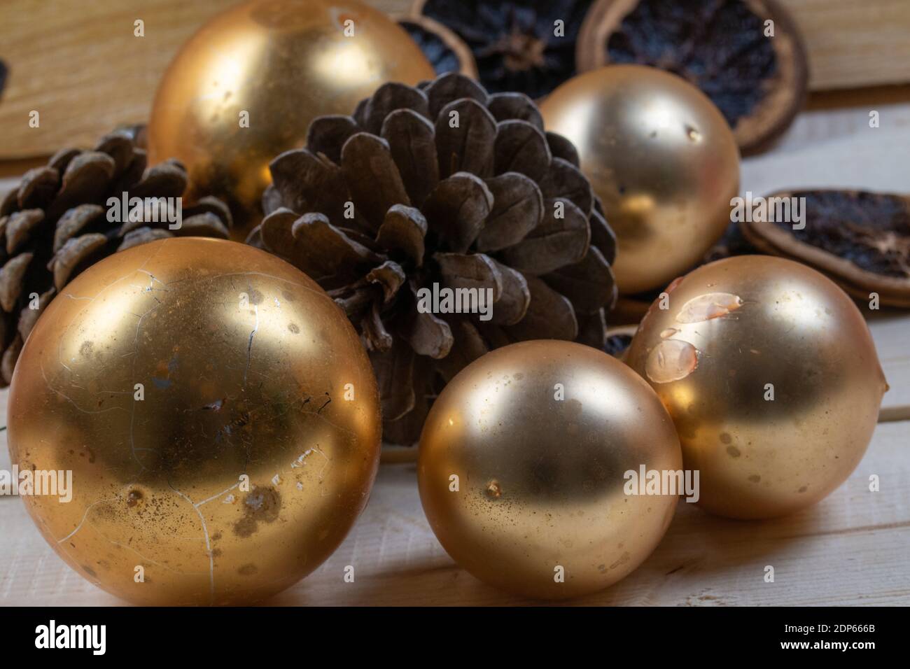 Old Christmas tree balls and pine cones on rustic wooden boards as Christmas decorations. Stock Photo