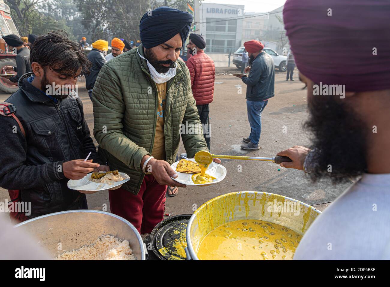 a sikh man serving food at protest site,farmers are protesting against new farm law in india. Stock Photo