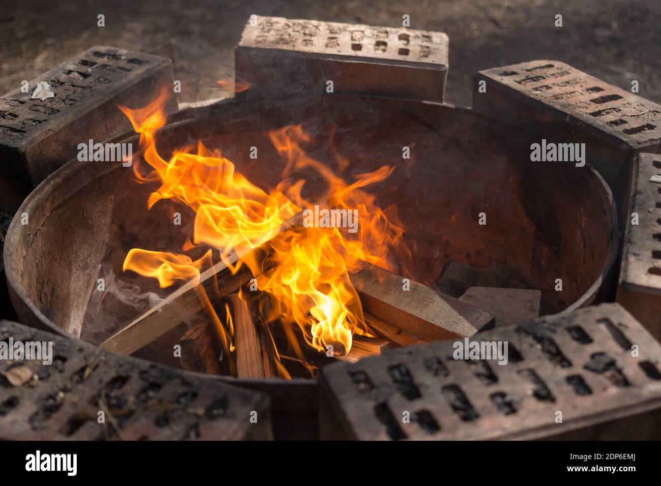 Burning fire on a round brick fireplace. Stock Photo