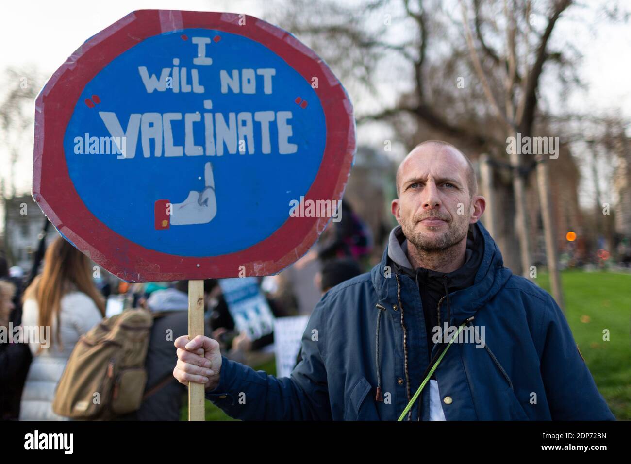 Protester holding a 'I will not vaccinate' placard during COVID-19 anti-vaccine protest, Parliament Square, London, 14 December 2020 Stock Photo