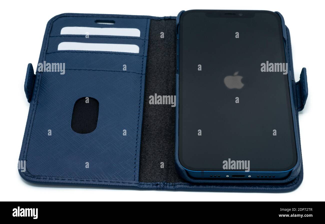 Ostfildern - Germany, December 5, 2020: Apple iPhone 12 in blue colour and stylish blue leather wallet with slight shadows on perfectly white Stock Photo