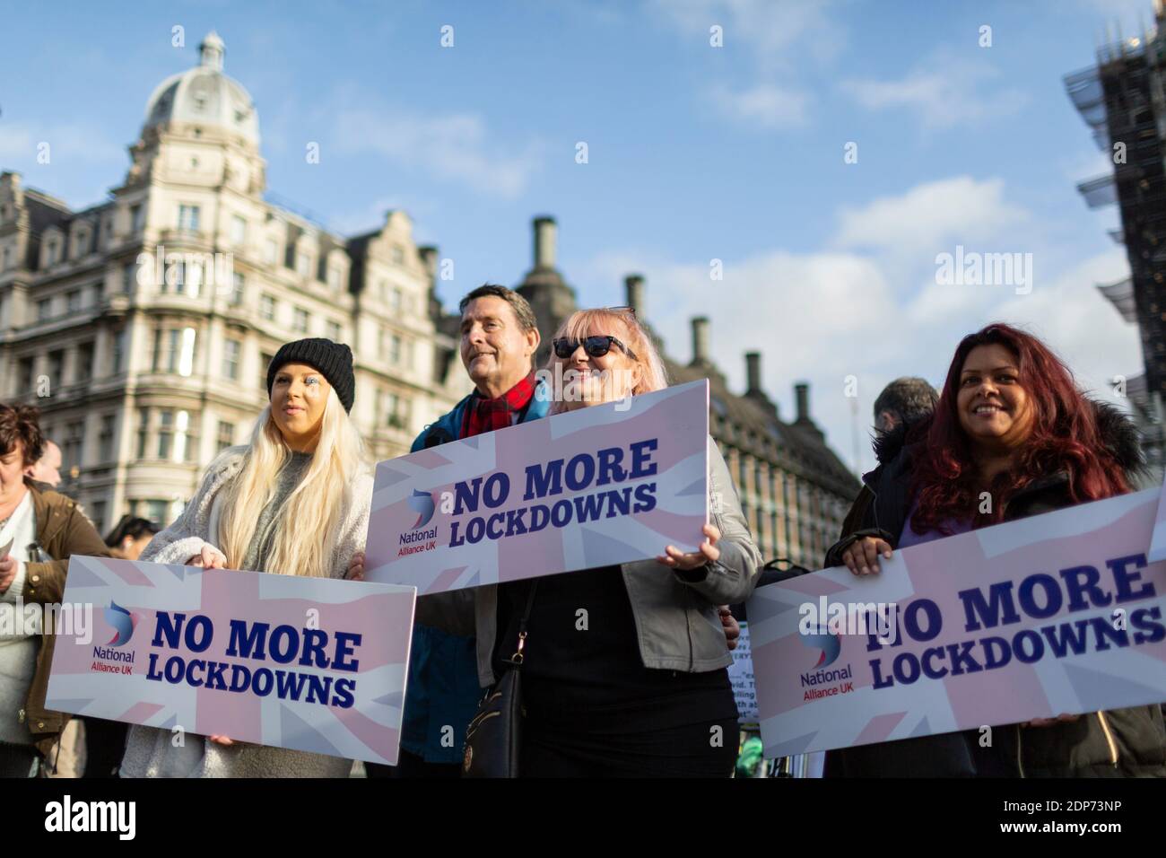 Protesters holding 'no more lockdowns' placards during COVID-19 anti-vaccine protest, Parliament Square, London, 14 December 2020 Stock Photo