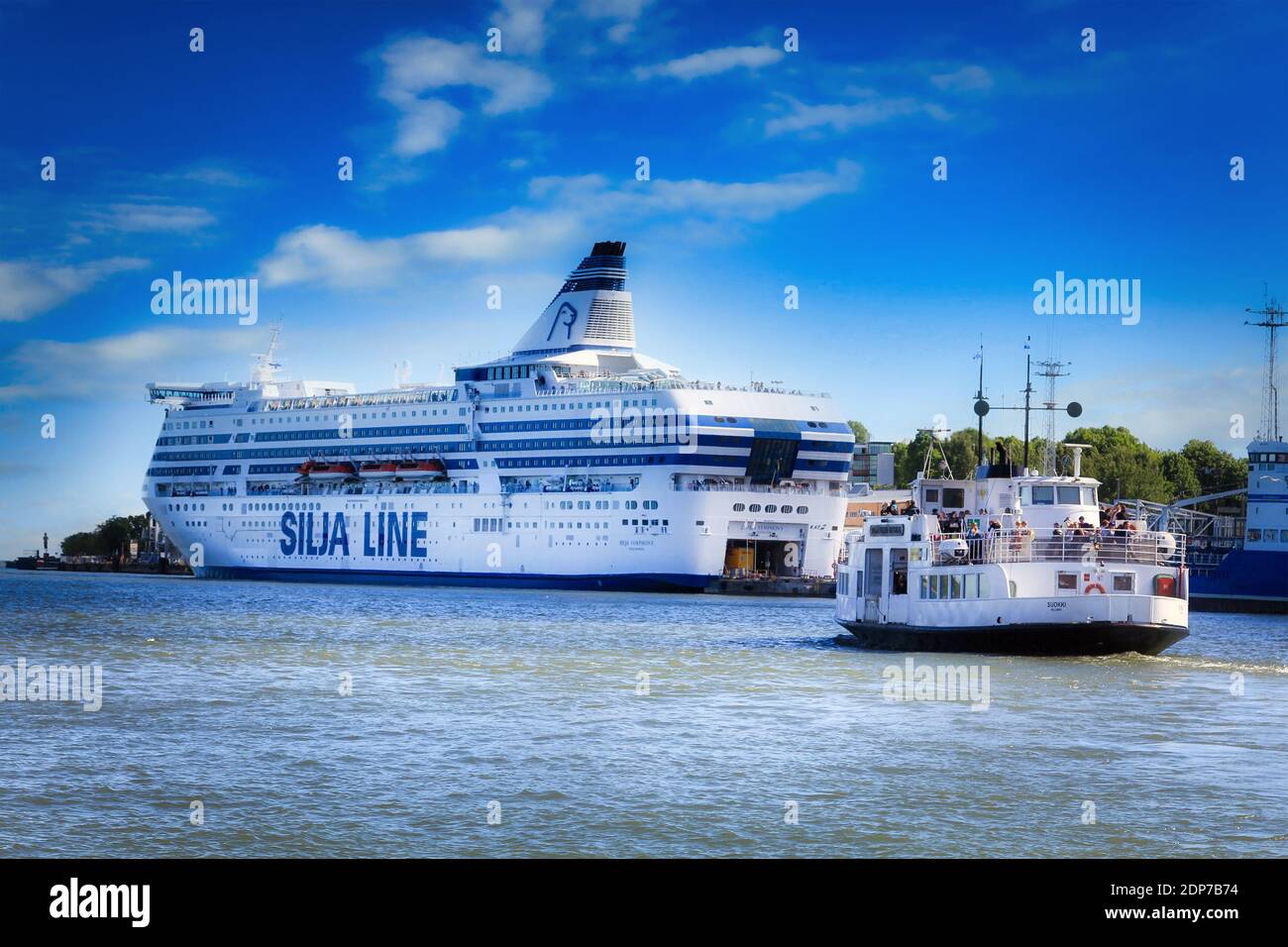 Silja Symphony cruise ferry docked in South Harbour and Suokki Helsinki-Suomenlinna ferry sailing on a sunny day. Helsinki, Finland. June 28, 2017. Stock Photo