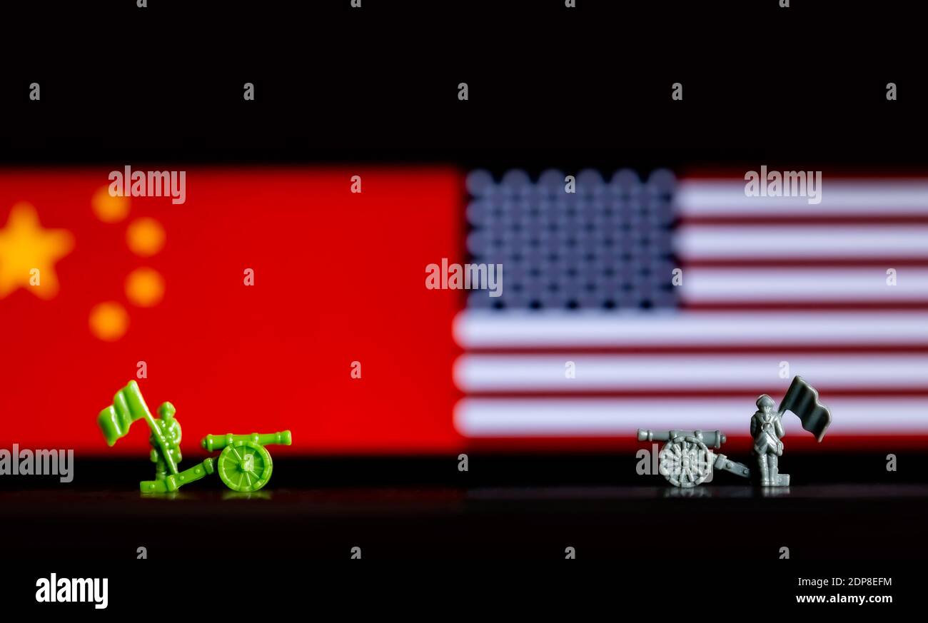 A closeup of toy war figurines on background of the Chinese and US