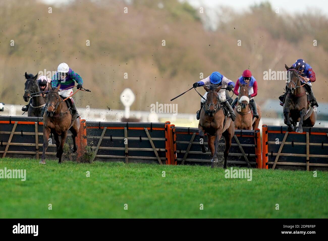 Aidan Coleman riding Paisley Park (right, spotted cap) clear the last to win The Porsche Long Walk Hurdle from Richard Johnson and Thyme Hill (left, white cap) during the Saturday of the December Racing Weekend at Ascot Racecourse. Stock Photo