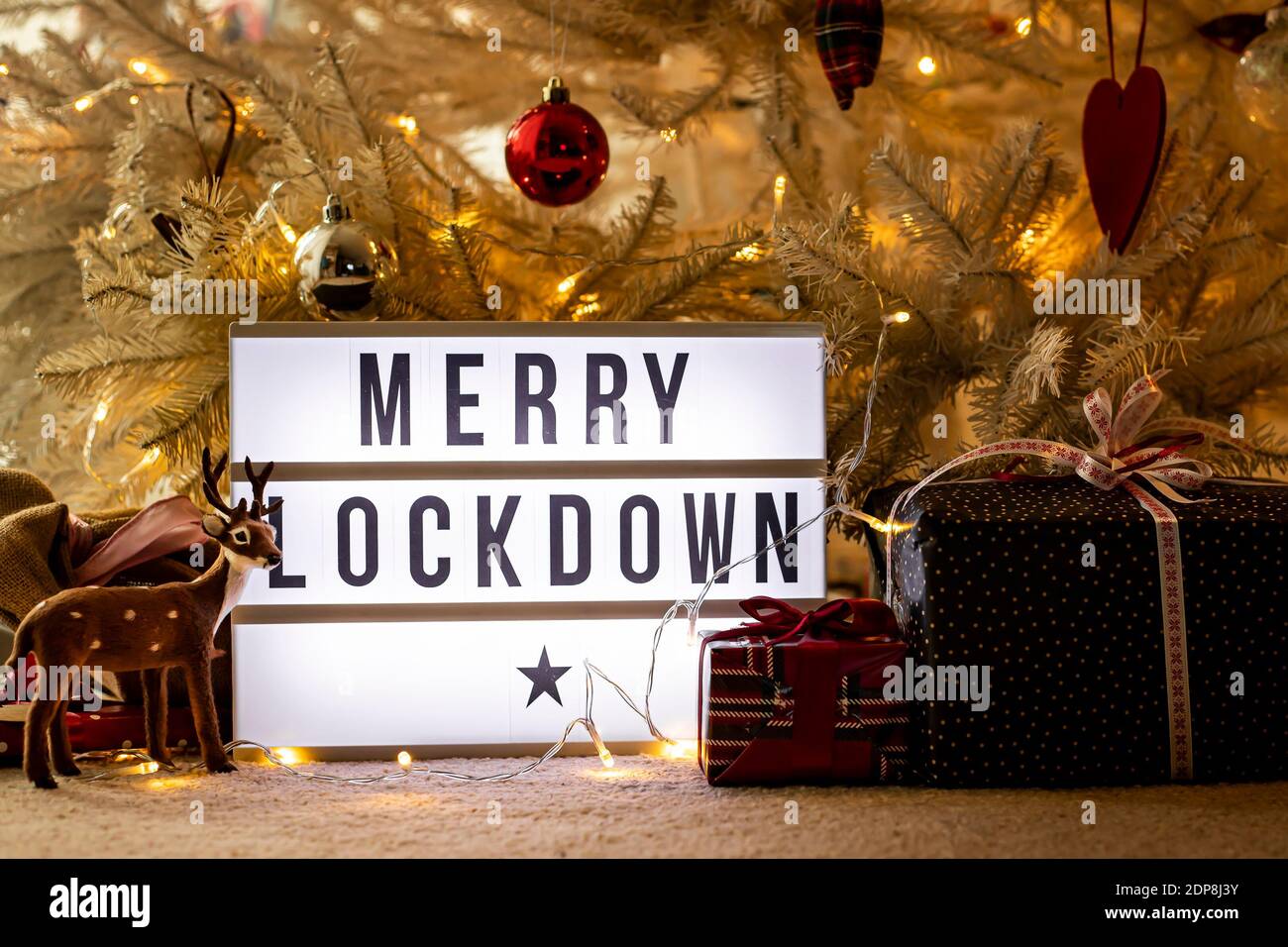 Lightbox under Christmas tree, with presents and toy deer, saying