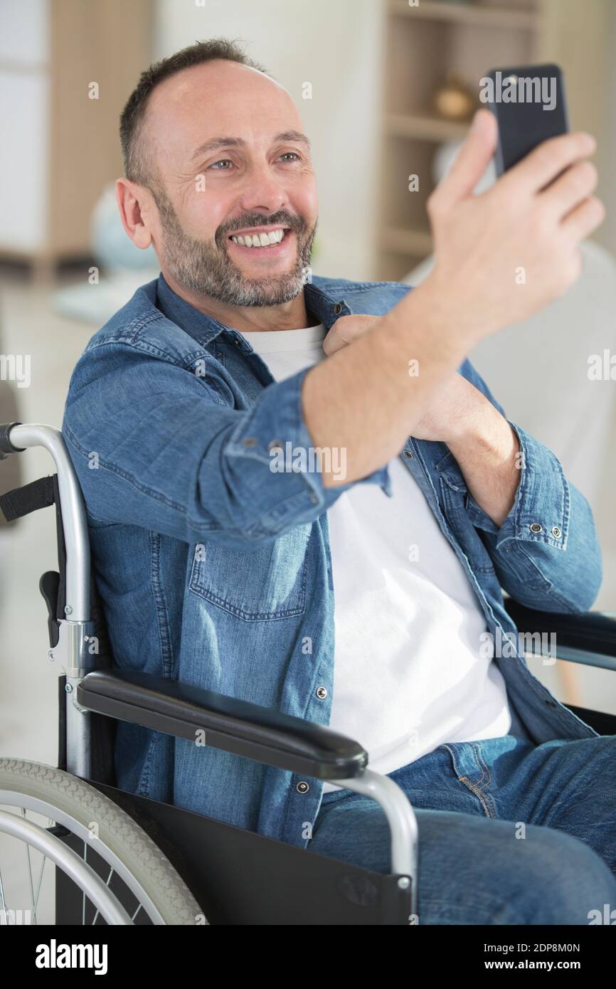 disabled man in a wheelchair taking a selfie Stock Photo - Alamy
