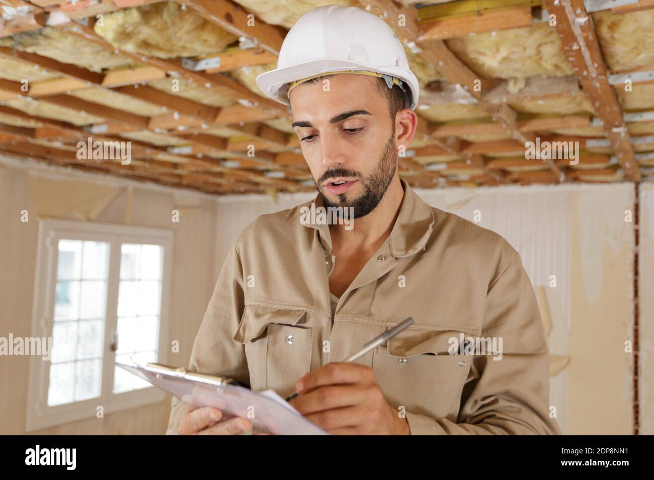 young builder making notes in a property Stock Photo