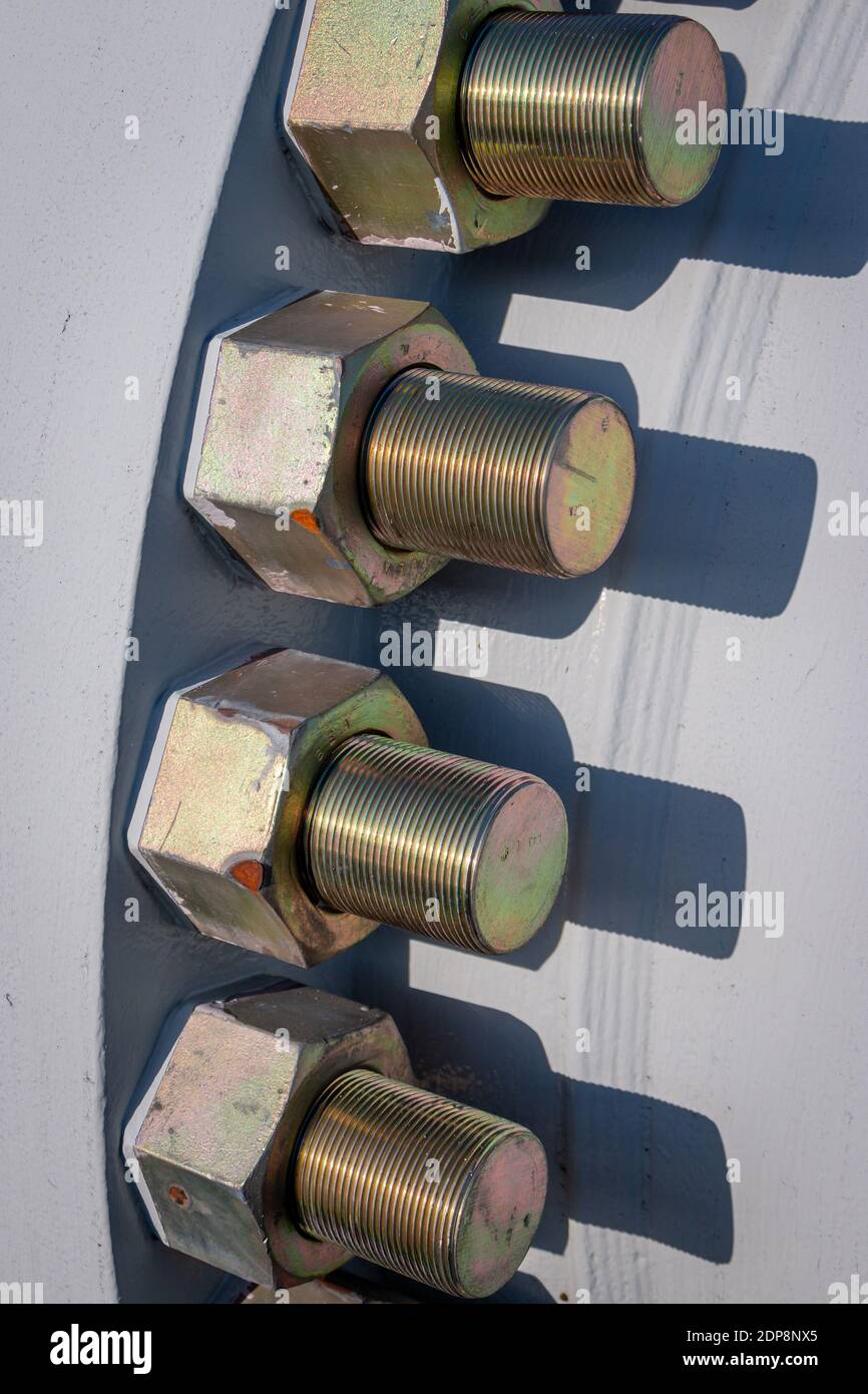 Large heavy galvanized industrial bolts and nuts mounted in a large