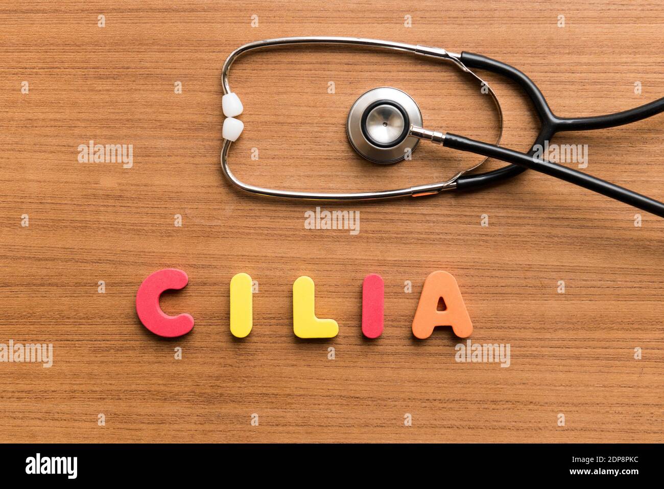 Directly Above Shot Of Stethoscope With Colorful Text On Wooden Table Stock Photo