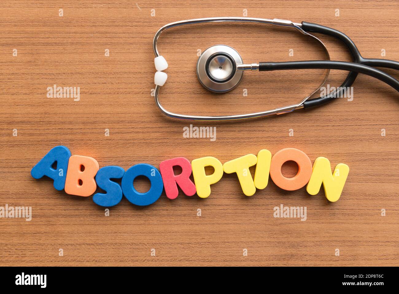 Directly Above Shot Of Stethoscope With Absorption Text On Wooden Table Stock Photo