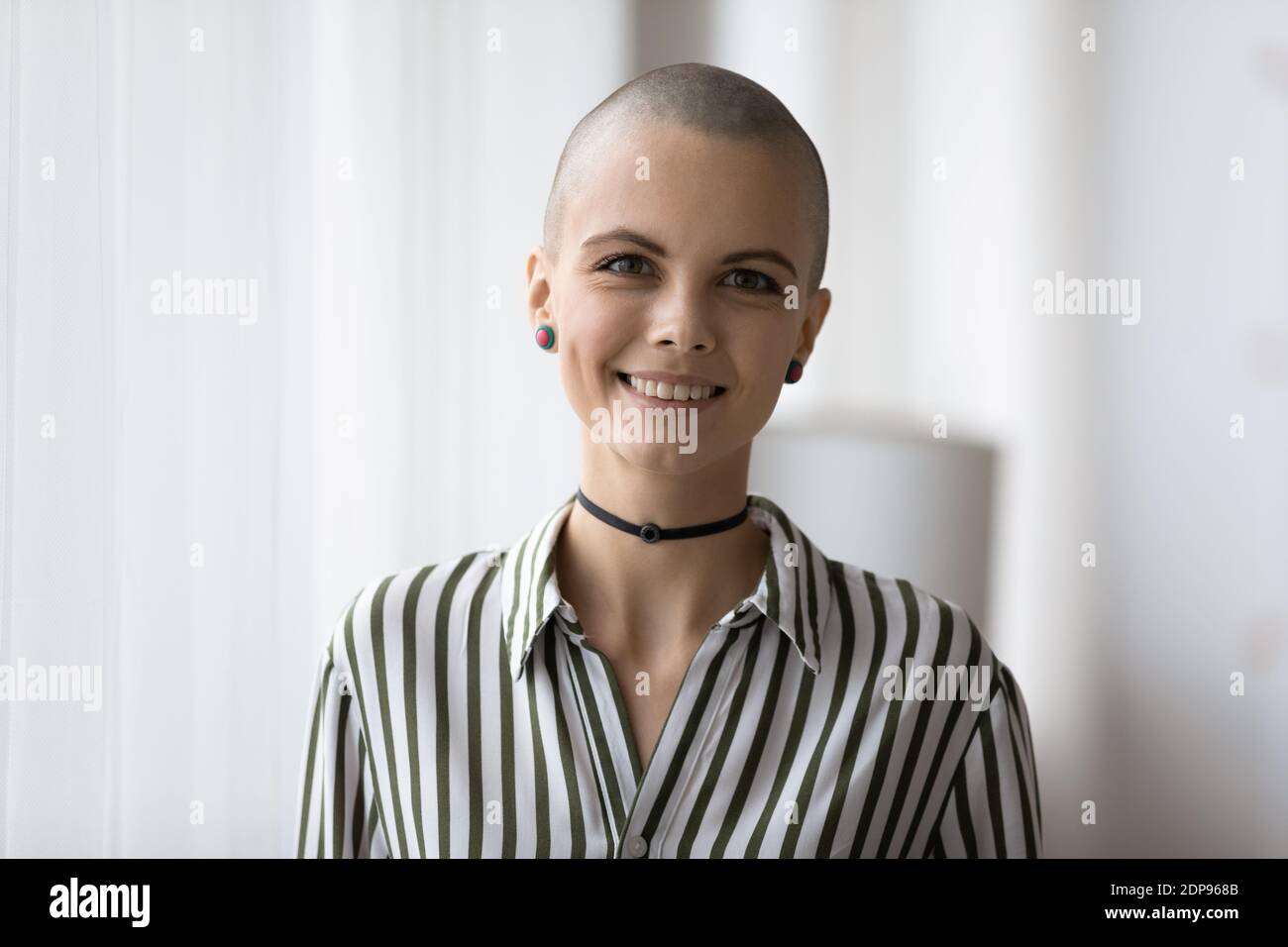Attractive millennial bald headed female informal person looking at camera Stock Photo