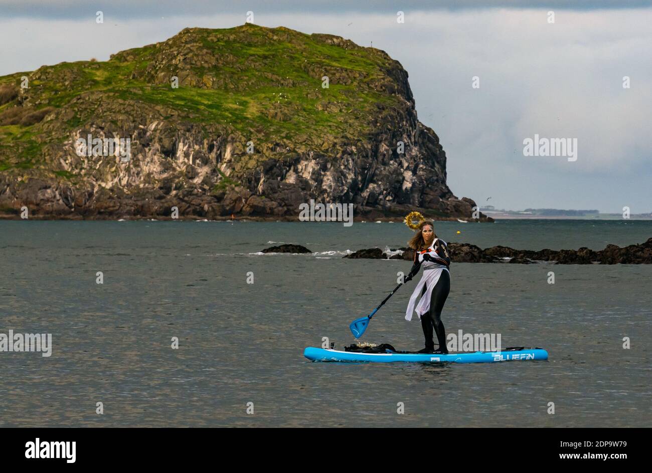 North Berwick, East Lothian, Scotland, United Kingdom, 19th December 2020. Paddle Boarding Santas for charity: a local community initiative by North Berwick News and Views called 'Christmas Cheer' raises over £5,000 funds for families in need. A paddle boarder wearing a festive angel costume Stock Photo