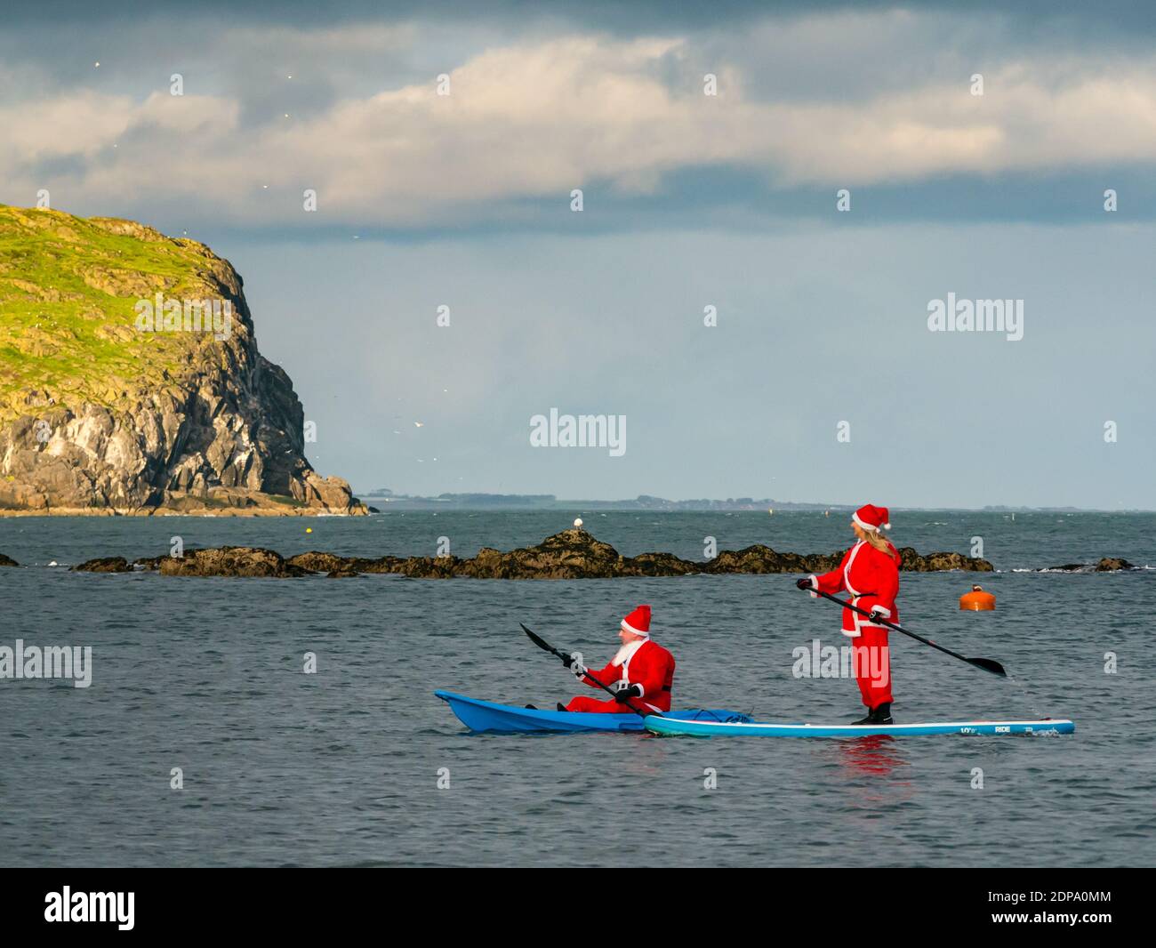 North Berwick, East Lothian, Scotland, United Kingdom, 19th December 2020. Paddle Boarding Santas for charity: a local community initiative by North Berwick News and Views called 'Christmas Cheer' raises over £5,000 funds for families in need Stock Photo