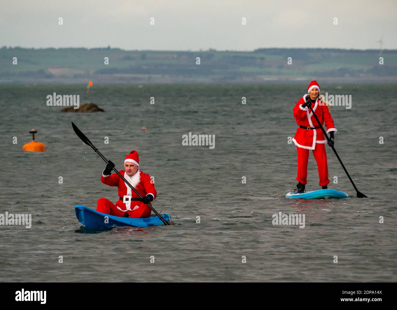 North Berwick, East Lothian, Scotland, United Kingdom, 19th December 2020. Paddle Boarding Santas for charity: a local community initiative by North Berwick News and Views called 'Christmas Cheer' raises over £5,000 funds for families in need. A paddle boarder dressed in a Santa costume Stock Photo