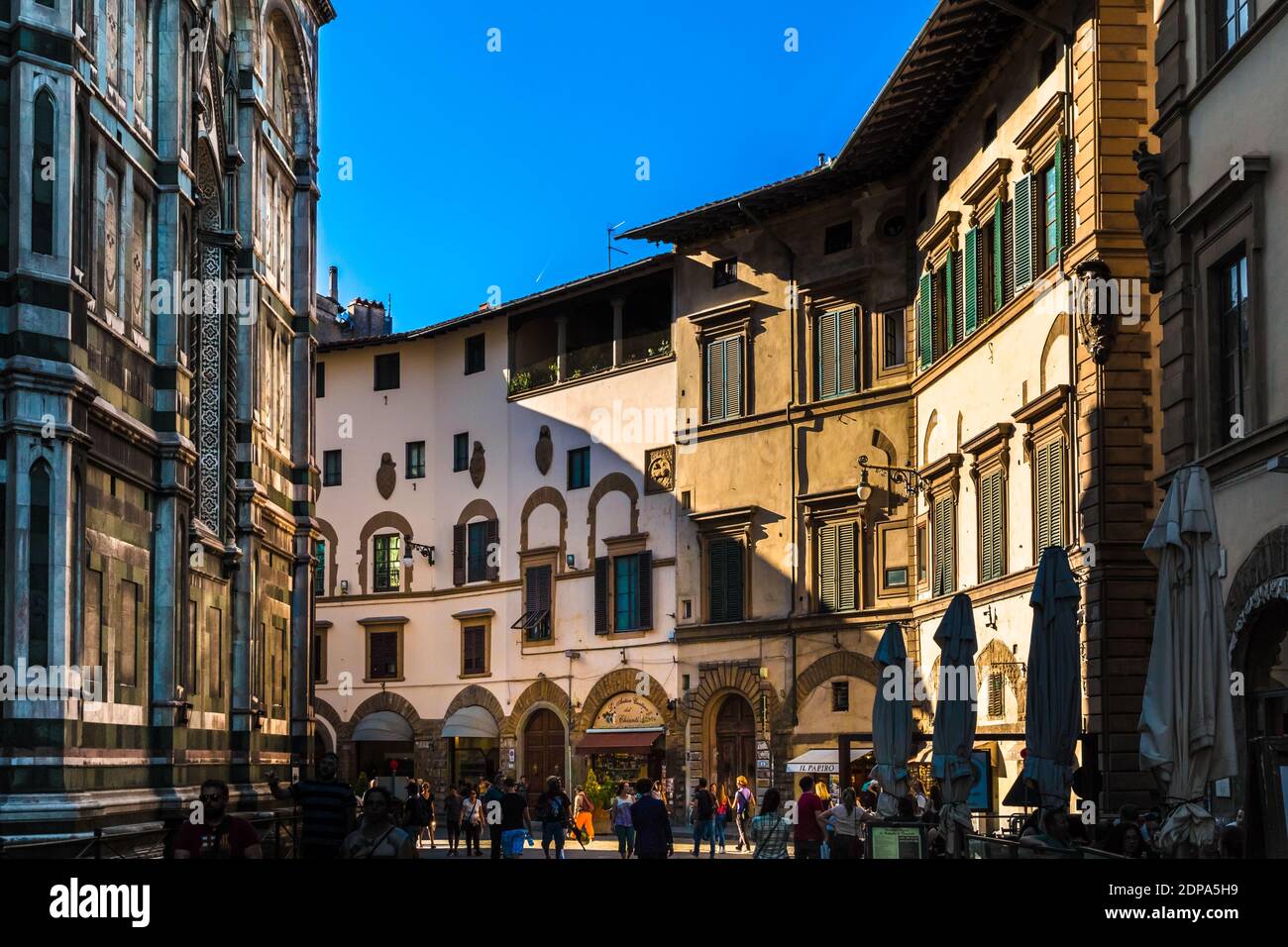 Great view of the Piazza del Duomo at the shaded northern flank of the famous Florence Cathedral Santa Maria del Fiore with shops and restaurants on... Stock Photo