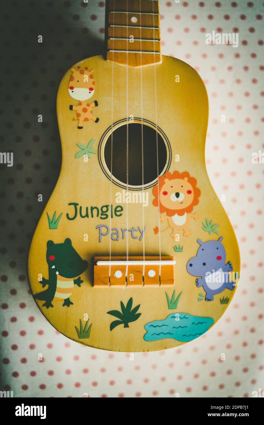 A top view of a ukulele decorated with cartoon characters on the table  under the lights Stock Photo - Alamy