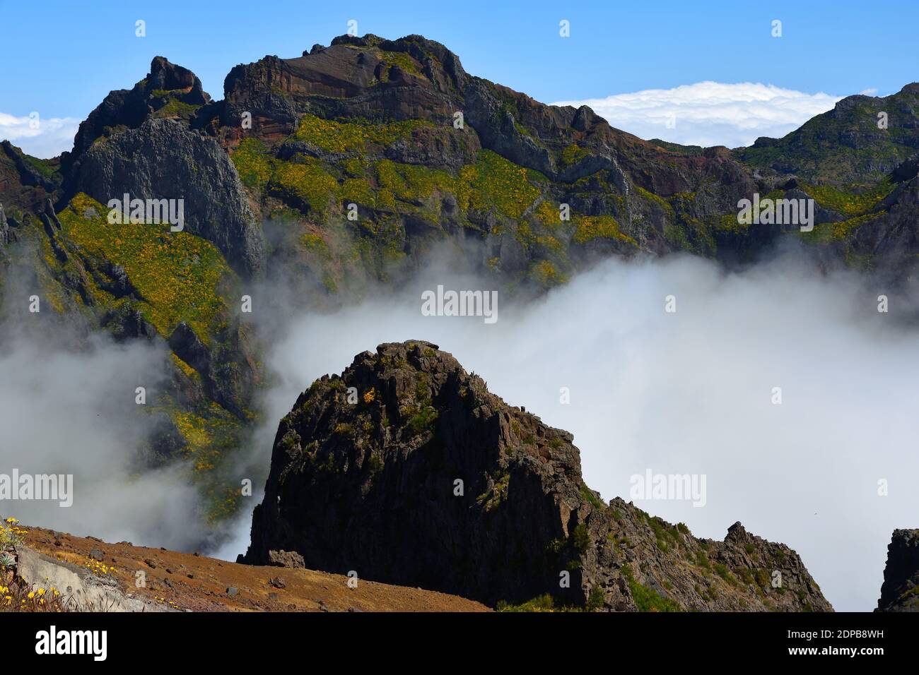 Pico do Areeiro Madeira peaks  among clouds with blue sky above. Stock Photo
