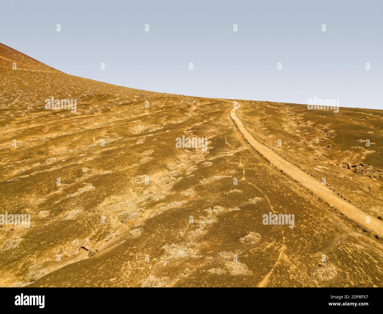 Aerial view of a trekking route, path that leads to the top of the Bermeja mountain near Las Conchas beach. Lanzarote, Canary island. Spain Stock Photo