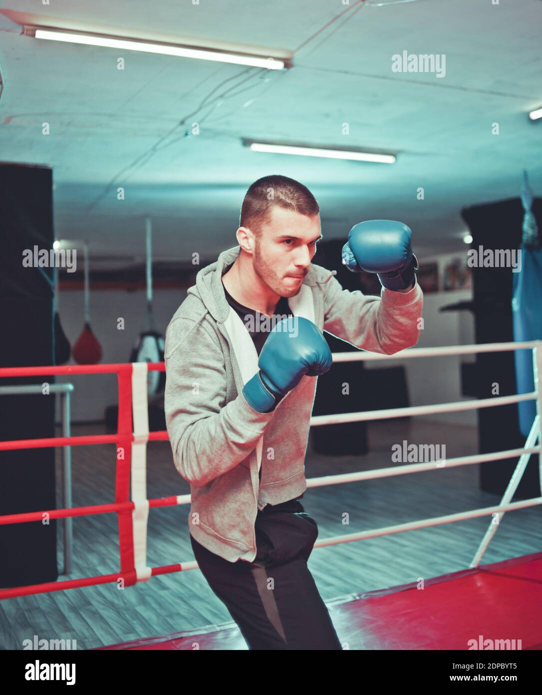 Sports guy boxer boxing in the ring at the gym. The process of training ...
