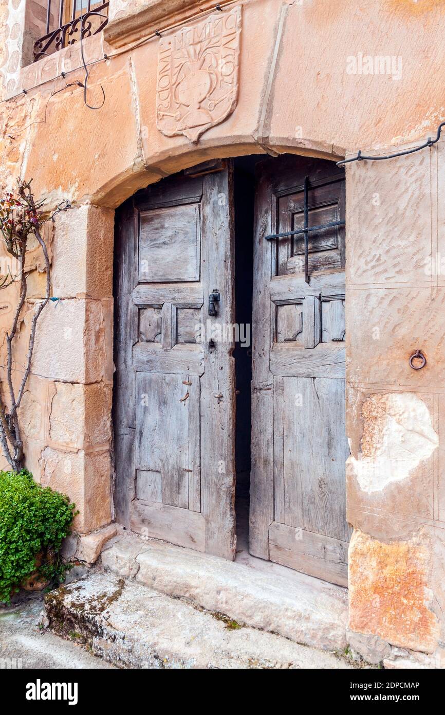 Antigua puerta de madera entre abierta. Palazuelos. Guadalajara. Castilla la Mancha. España. Stock Photo