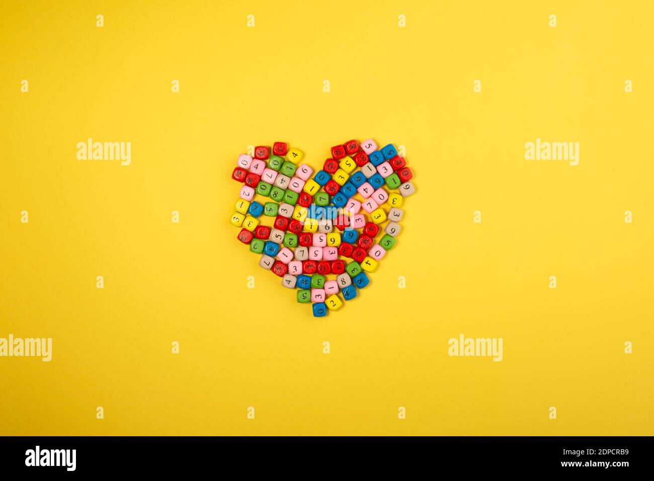 Heart shape made of small colourful bricks with number on bright yellow background. Thank you teacher or accountant concept. Stock Photo