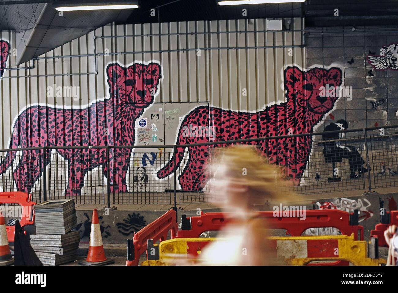 GREAT BRITAIN / London/ Street Art /A woman walks past a  graffiti artwork /A subway painted by stencil artists at a giant new exhibition space create Stock Photo