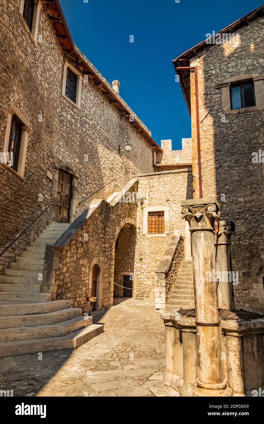 September 13, 2020 - Capestrano, Abruzzo, Italy - The courtyard of the ancient medieval castle, with the well, the defensive brick walls, the staircas Stock Photo