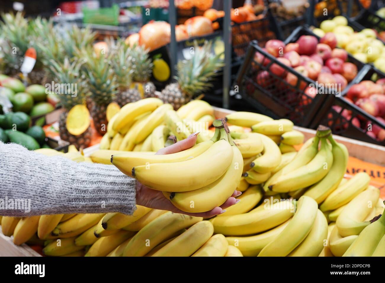 girl hand take bananas from shelf of store. healthy food. shopping