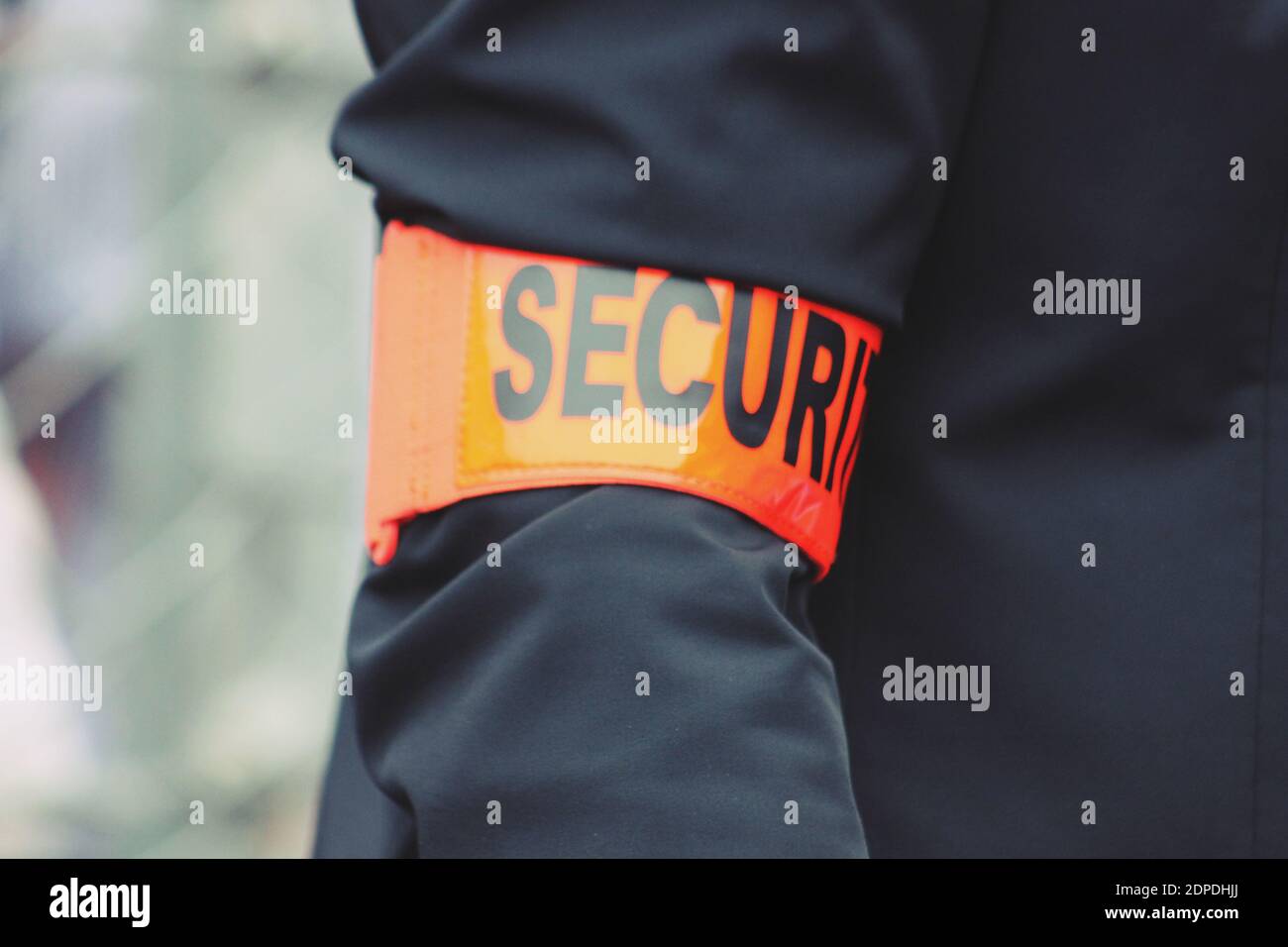 Midsection Of Security Guard Wearing Badge While Standing Outdoors