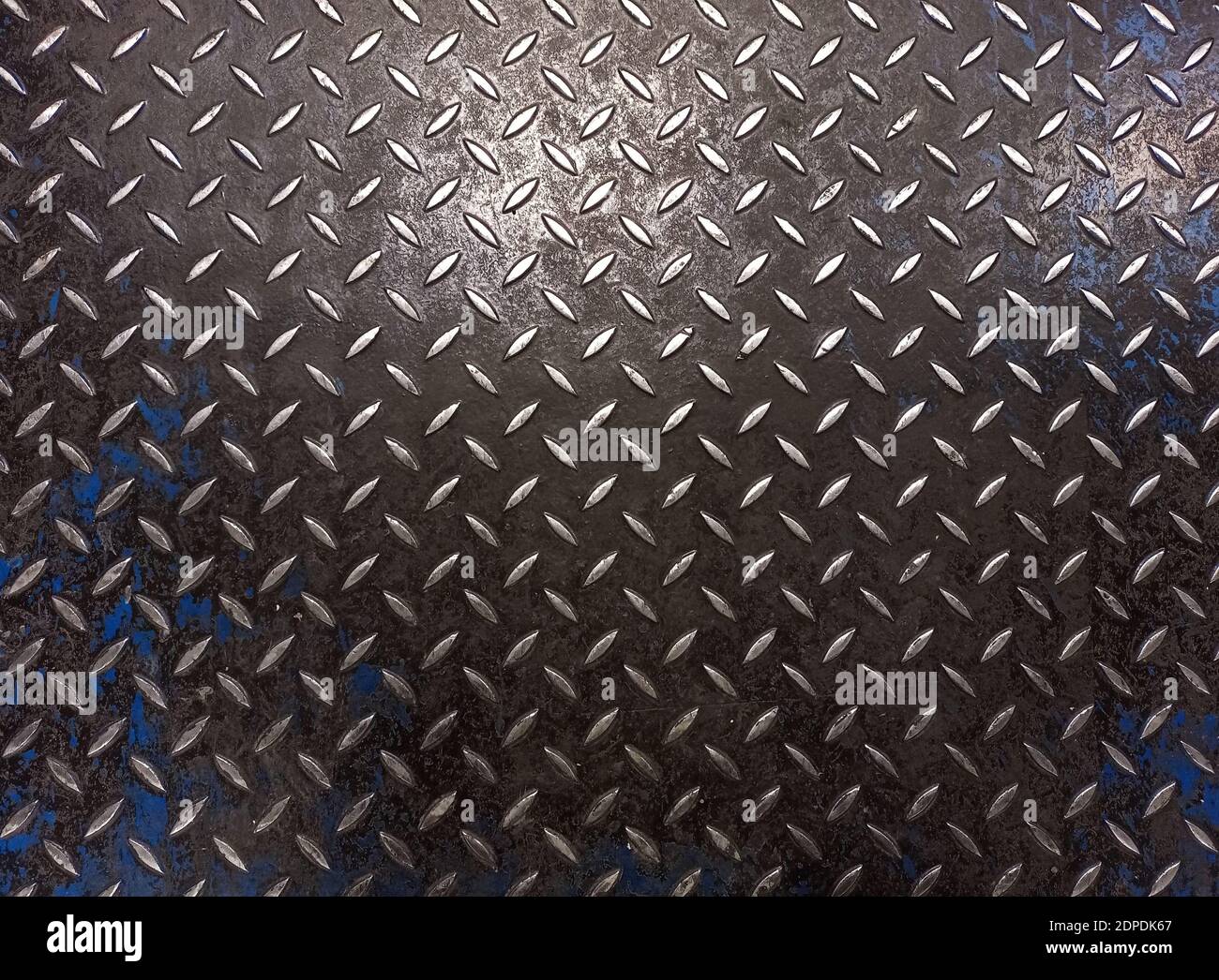 Embossed metal texture with traces of black and blue paint Stock Photo