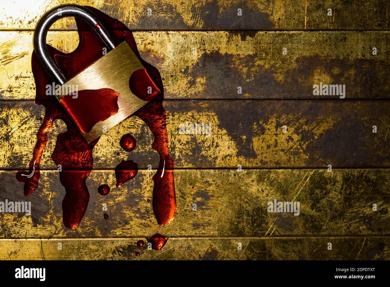 Bleeding lockdown padlock on grunge textured copper and gold background with copy space symbolizing mental and economic damage Stock Photo